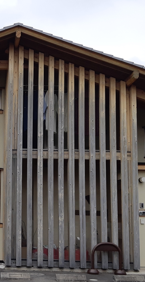 屋外の柱が黒く汚れて風化した建物